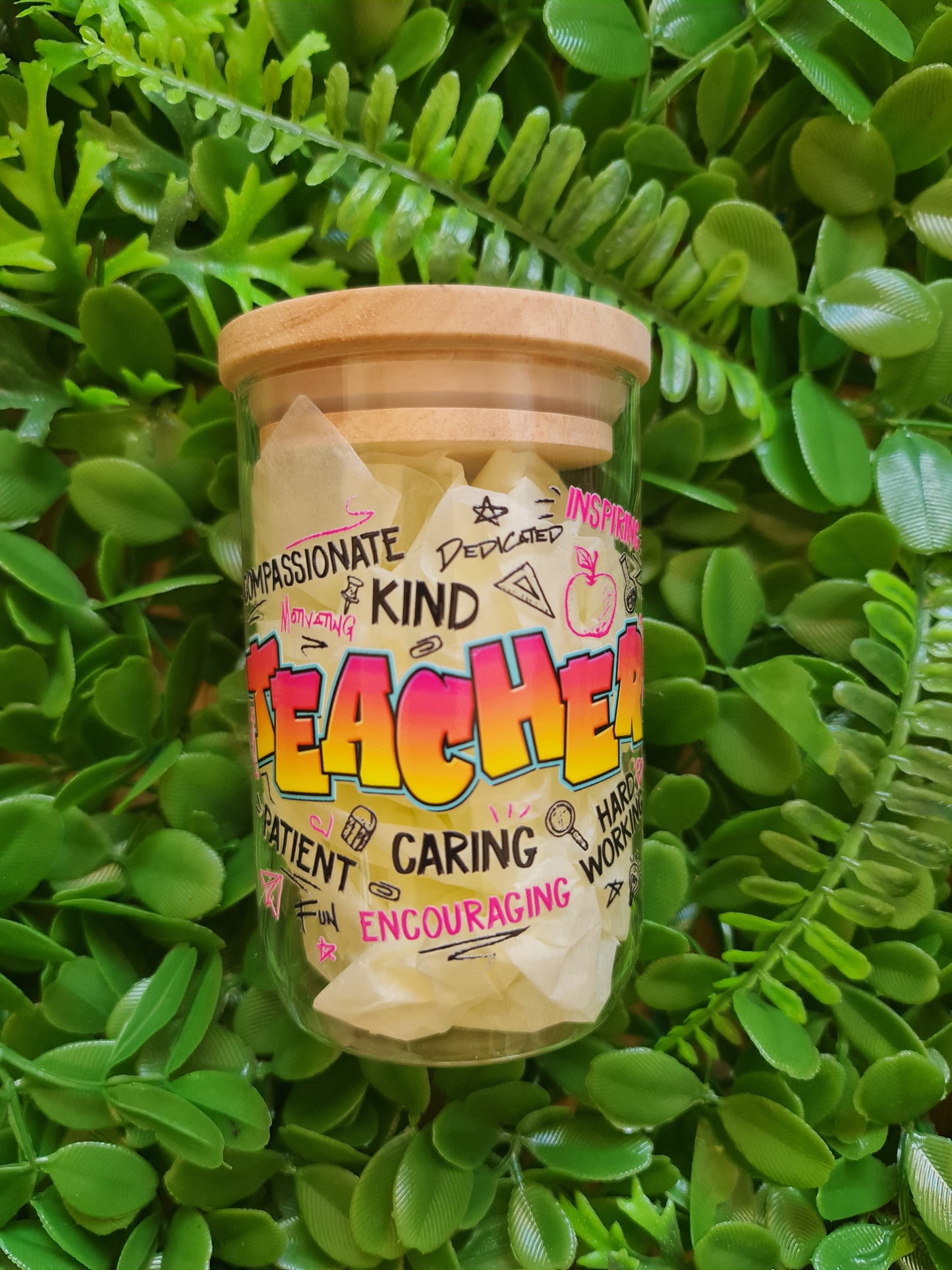 Jar labeled 'Teache' on a bed of green leaves