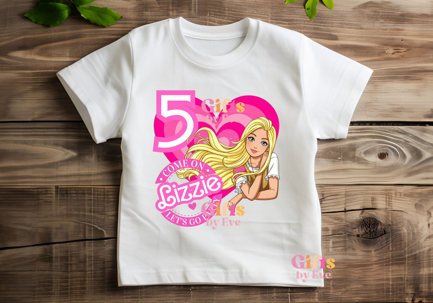 White t-shirt with a Barbie-themed design on a wooden surface