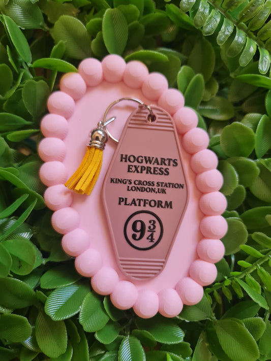 Pink keychain with 'Hogwarts Express' design on a green leafy background