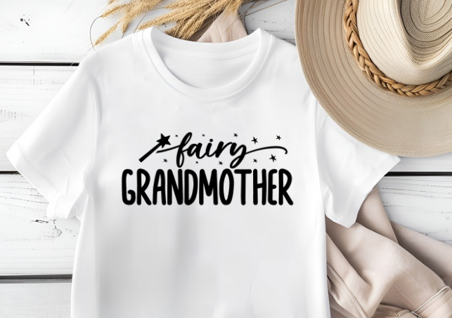 White t-shirt with 'fairy GRANDMOTHER' text on a wooden surface.