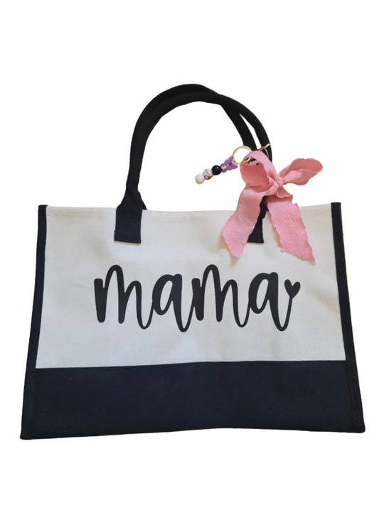 Tote bag with 'mama' text and pink bow on a wooden floor