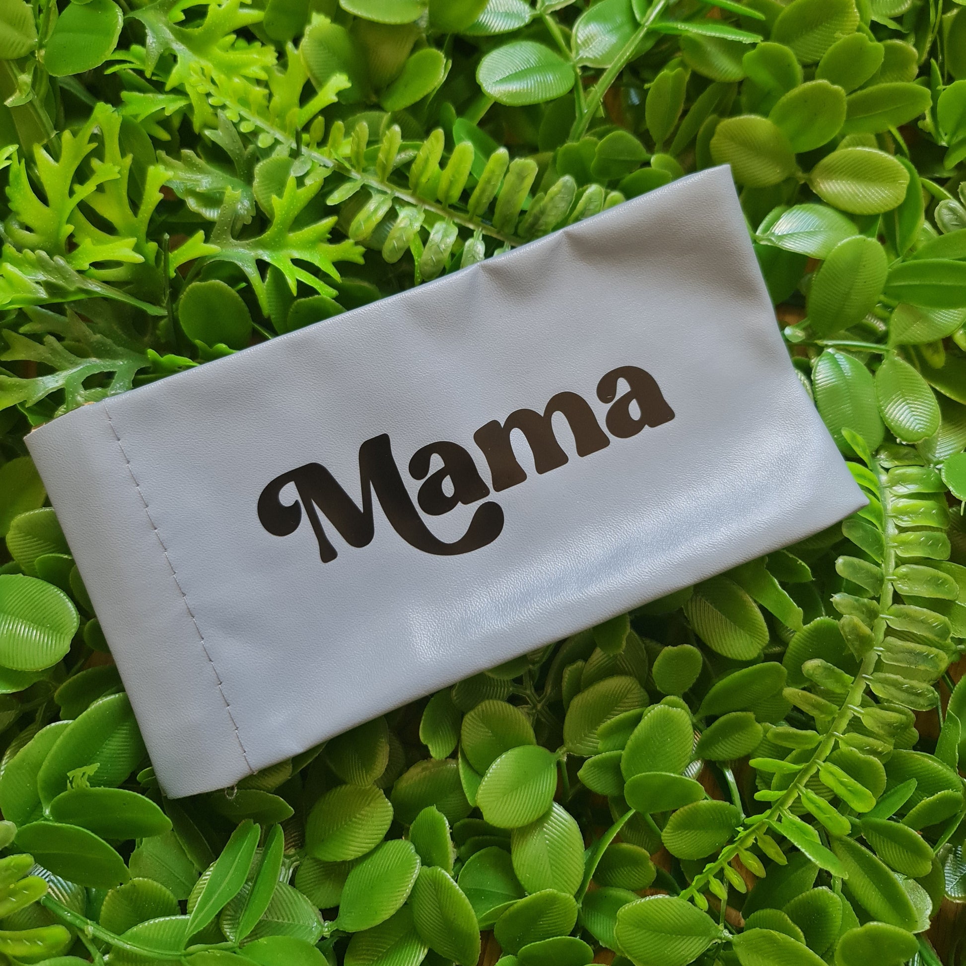 White pouch with 'MAMA' branding on a green leafy background