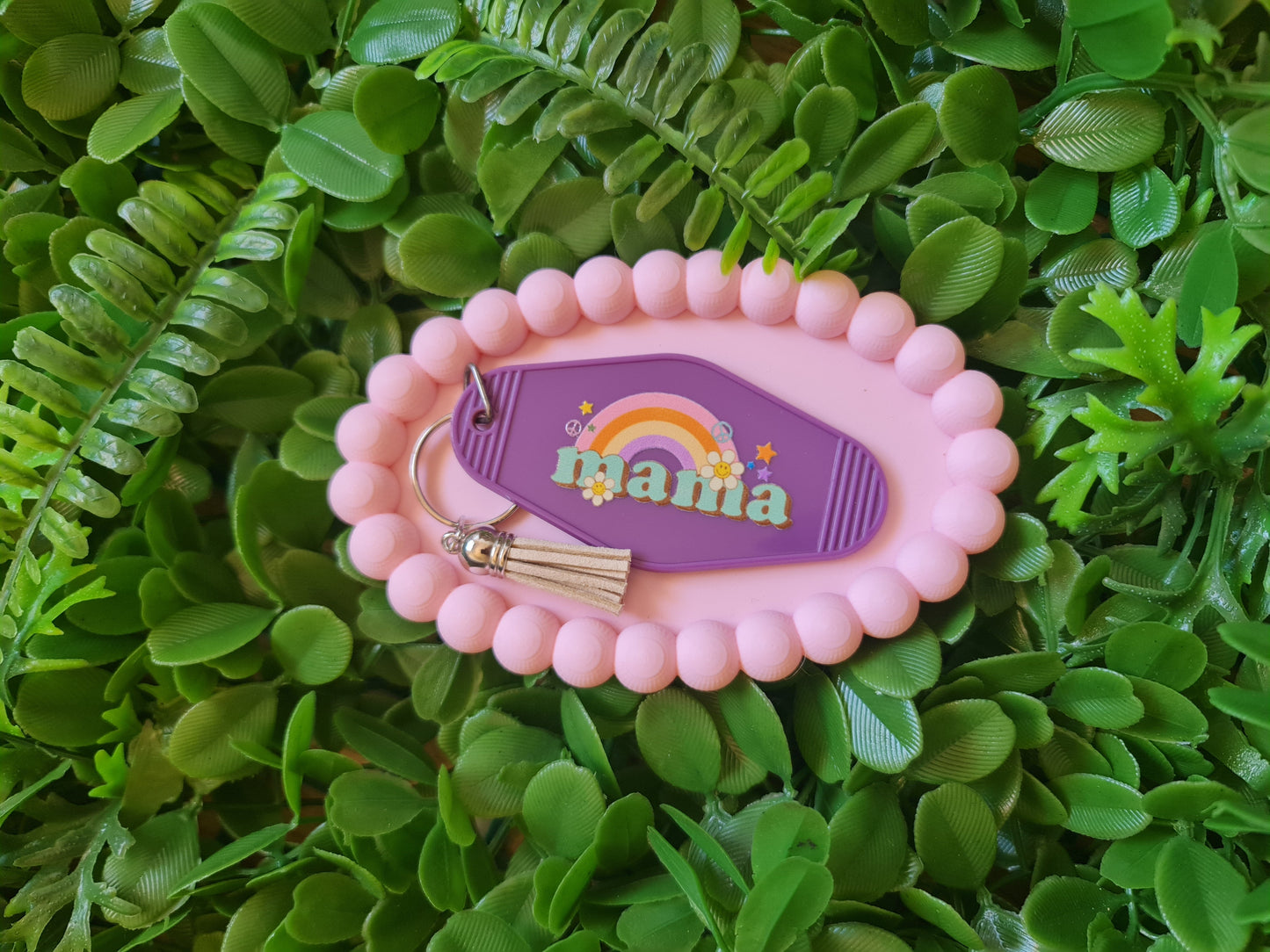 Pink keychain with 'mama' text on a green leafy background