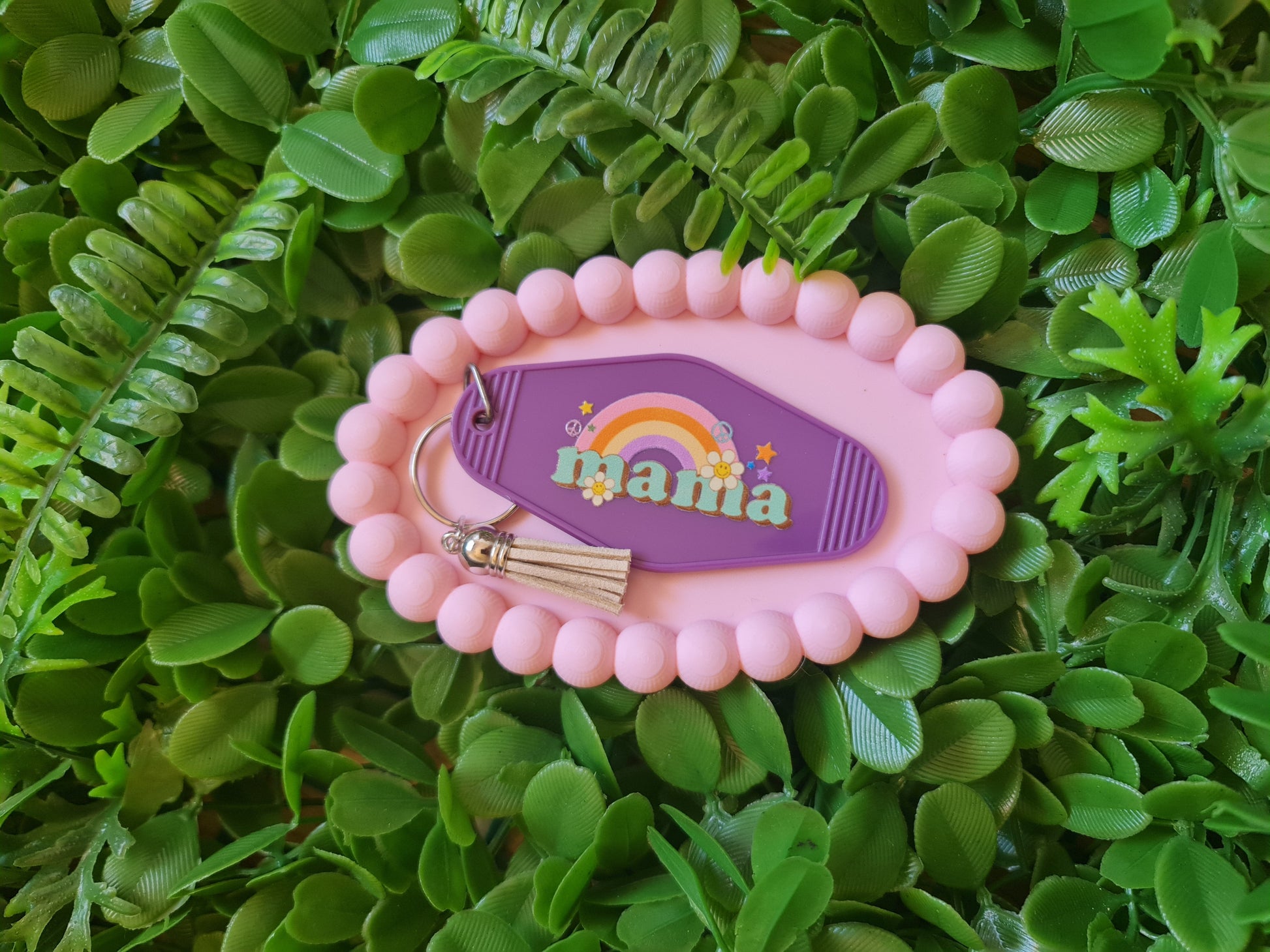 Pink keychain with 'mama' text on a green leafy background