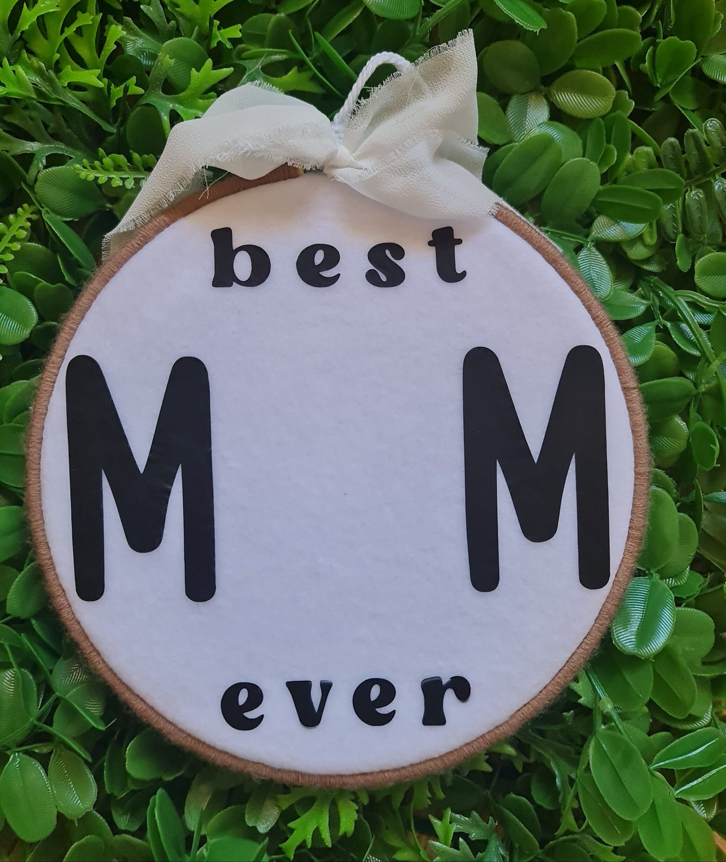 Decorative sign with 'best M ever' text on a green leafy background