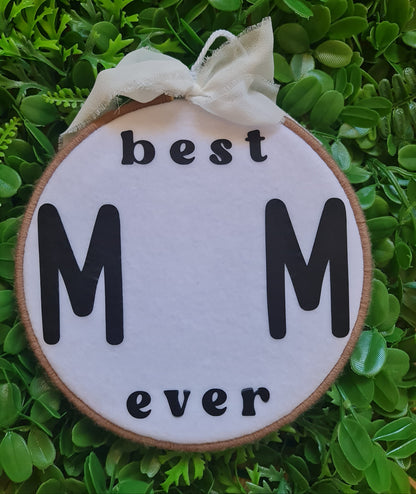 Decorative sign with 'best M ever' text on a green leafy background