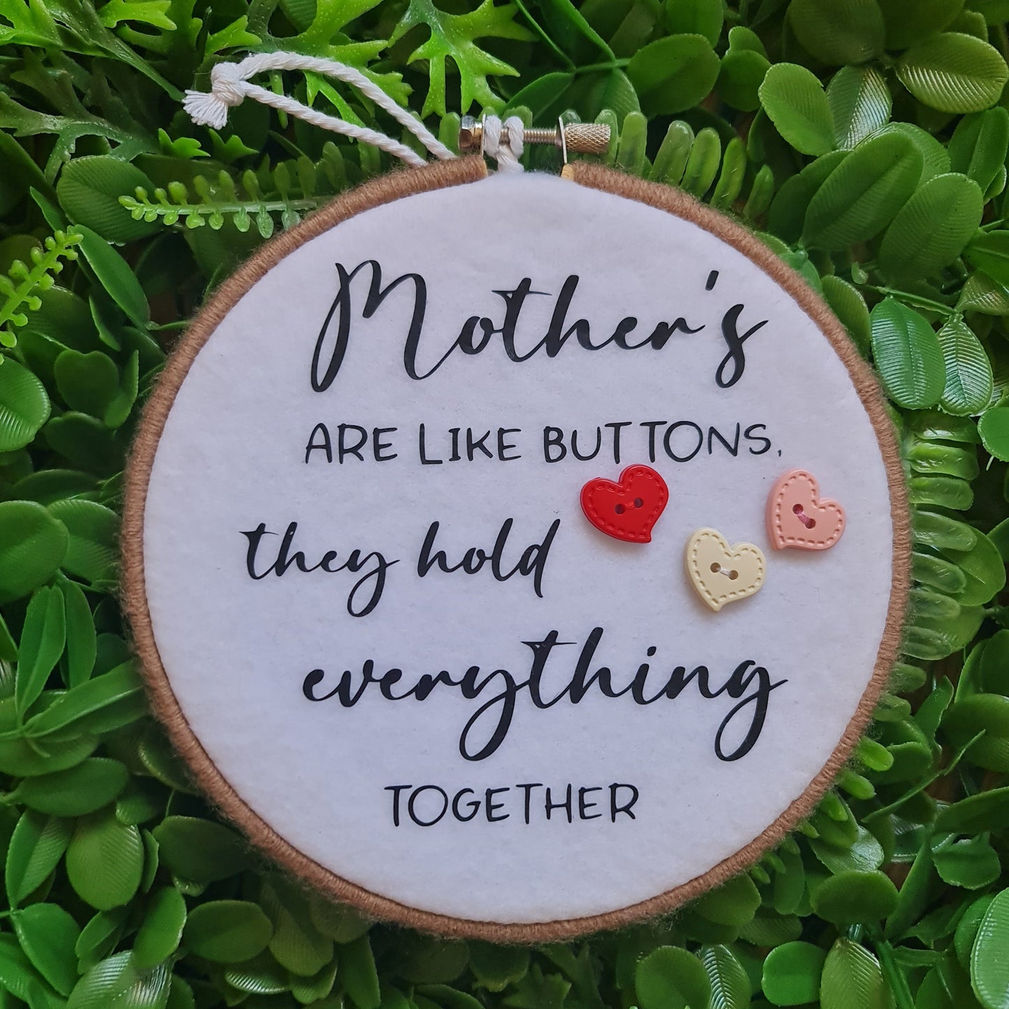 Decorative round sign with text and buttons on a green leafy background