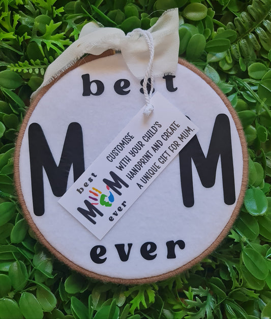 Round wooden sign with 'Mum ever' text on a grass background