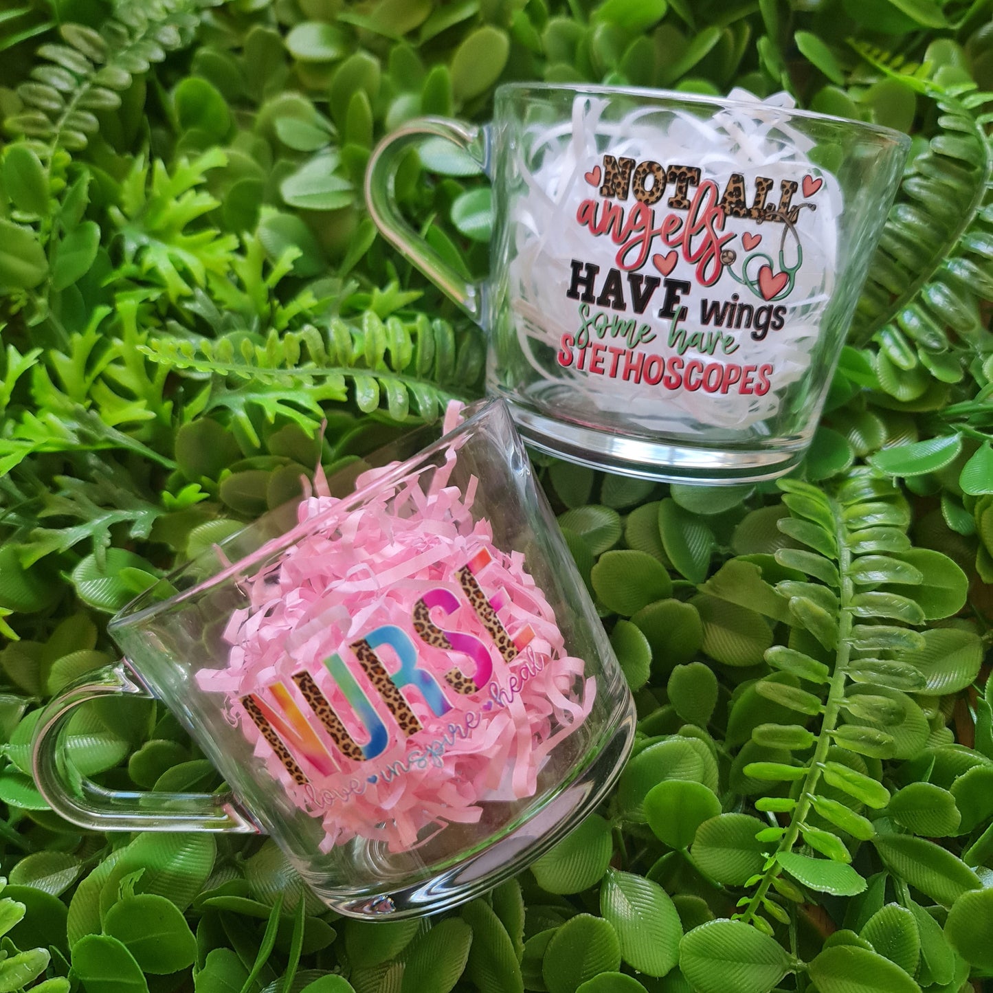 Two clear containers with colorful text and designs on a green leafy background