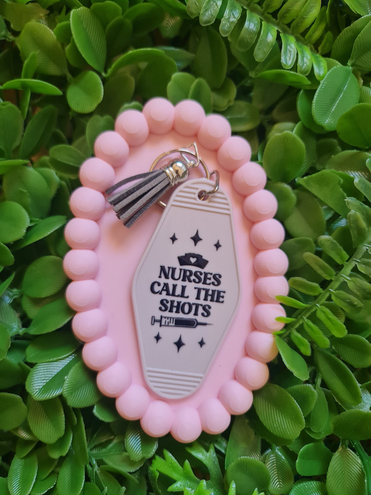 Pink decorative item with a tag on a green leafy background