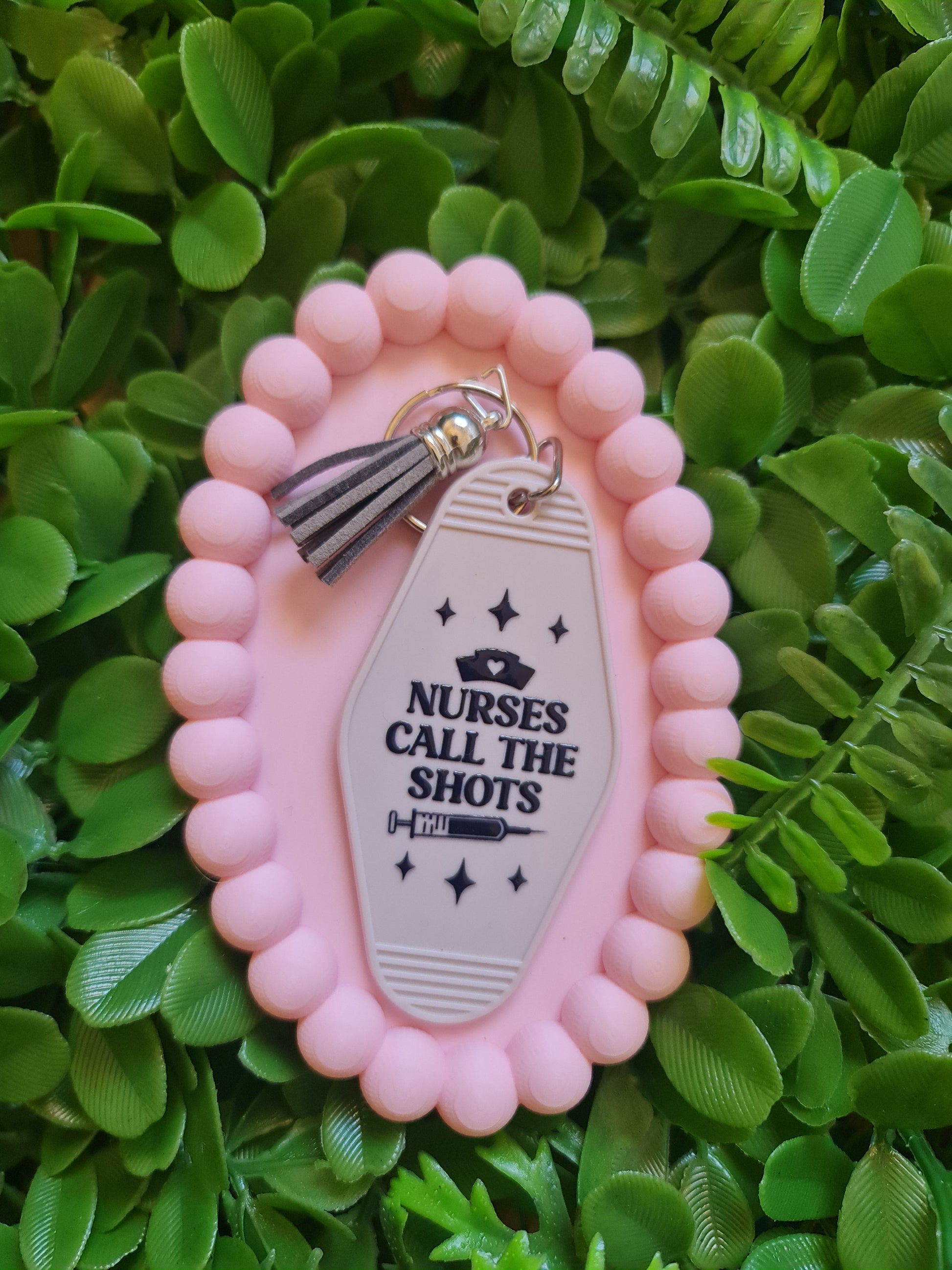 Pink decorative item with a tag on a green leafy background