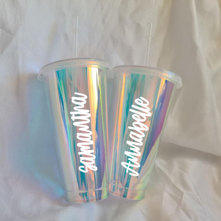 Iridescent tumbler with personalized names on a white fabric background