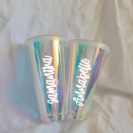 Iridescent tumbler with personalized names on a white fabric background