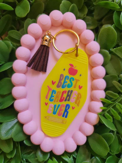 Pink keychain with 'Best Teacher Ever' tag on green leaves