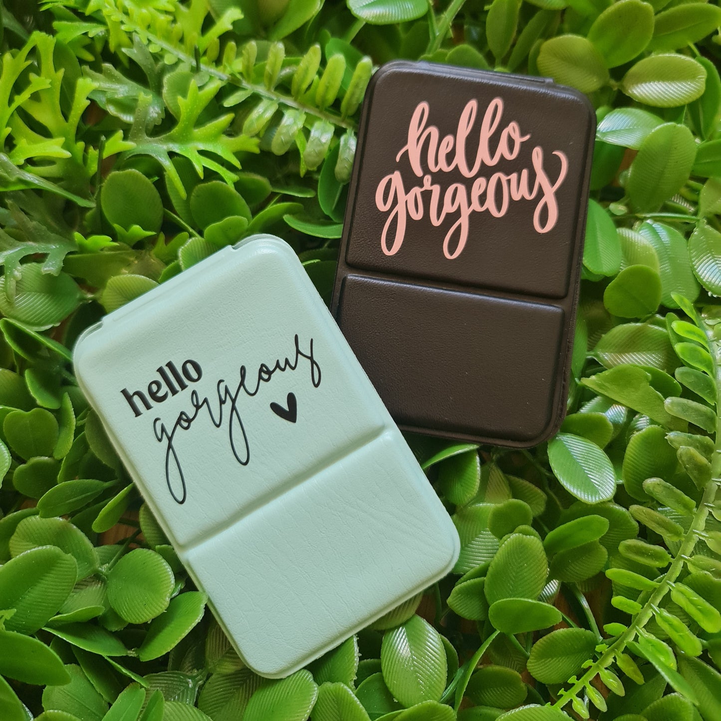 Two rectangular objects with text on a green leafy background