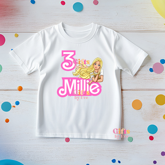White t-shirt with a Barbie design and text on a colorful polka dot background