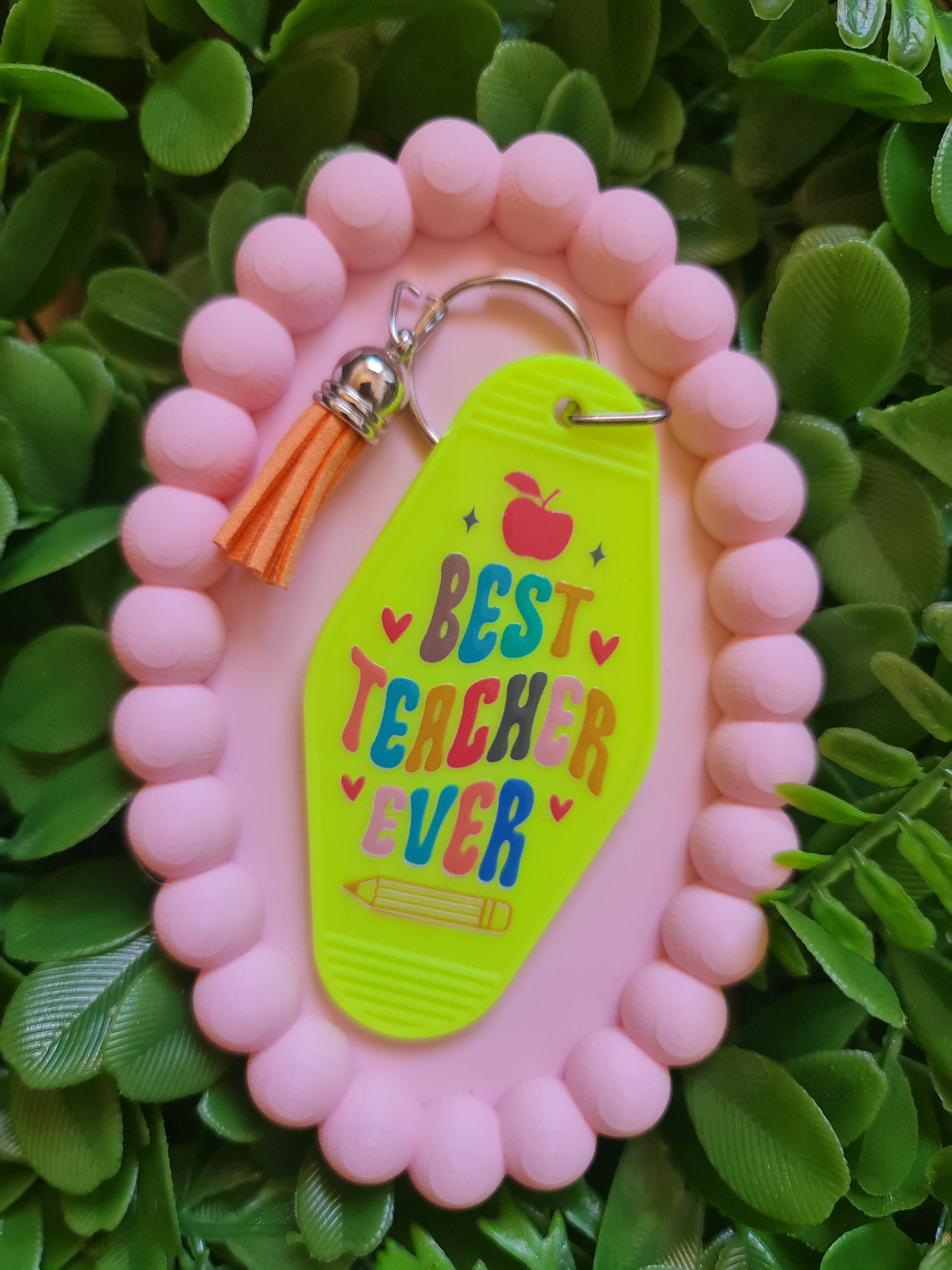 Pink keychain with 'Best Teacher Ever' tag on green leaves
