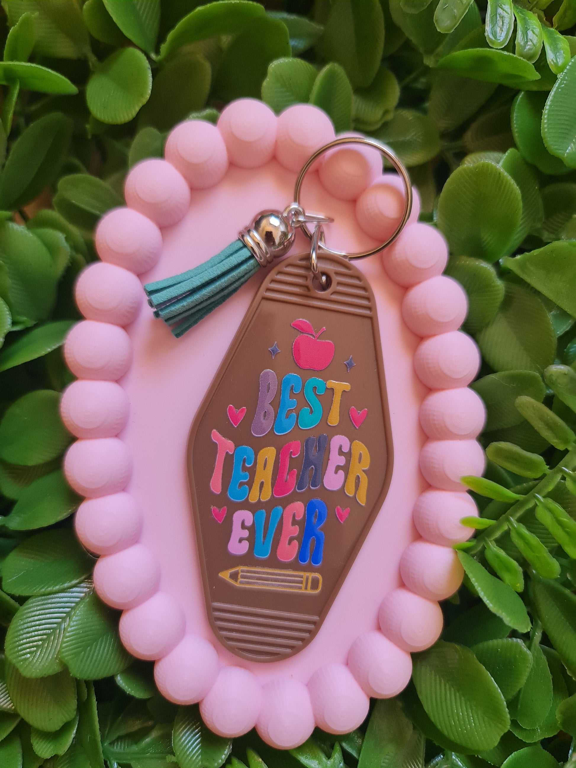 Pink beaded keychain with 'Best Teacher Ever' tag on green leaves