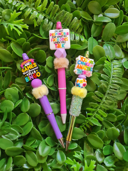Colorful pens with fuzzy ends on a green leafy background