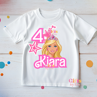 White t-shirt with a cartoon character and text on a wooden surface with colorful confetti.