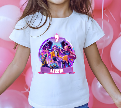 Child wearing a white t-shirt with a colorful graphic design in front of pink balloons.