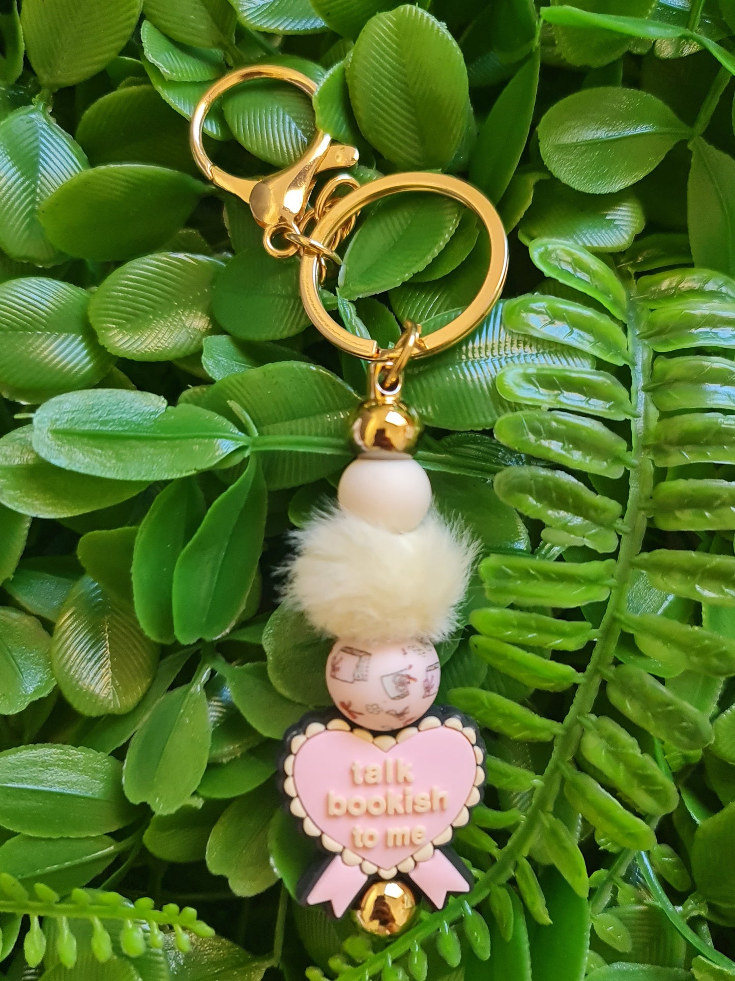 Keychain with decorative elements on a green leaf background