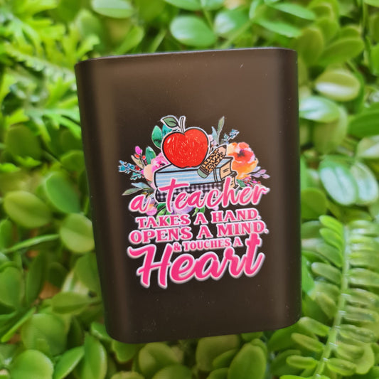 Black rectangular object with colorful design and text on a green leafy background