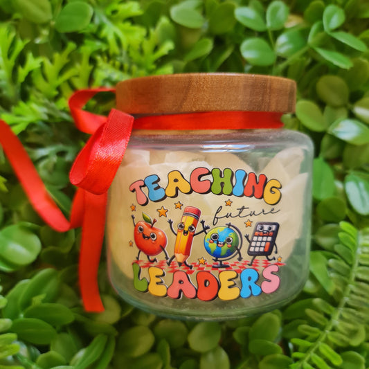Small jar with colorful text and cartoon characters on a green leafy background
